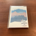 A boxed card set from Pike St. Press titled 'Heidi Kuchler Seattle' featuring a winter mountain landscape illustration, placed on a wooden tabletop.