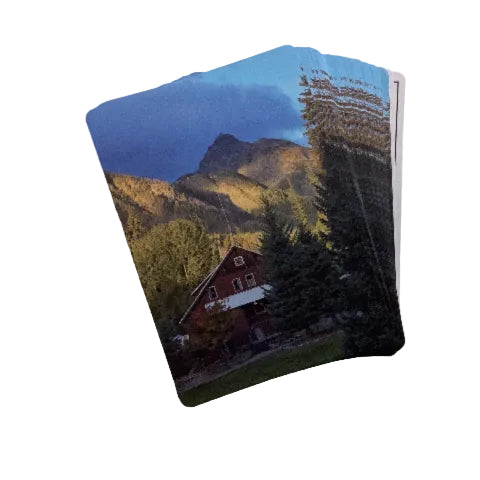 Card with a scenic design of a mountain and cabin on a beige background