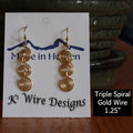 Gold wire earrings on a 'Made in Heaven K3 Wire Designs' card with a blurred background.