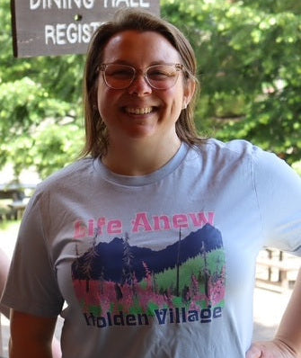 Person wearing a t-shirt with 'Life Anew Holden Village' design outdoors