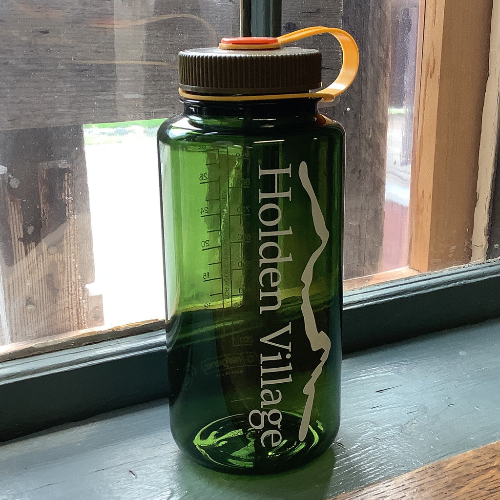 A translucent dark green Nalgene water bottle with 'Holden Village' printed vertically in white. Dark green top w yellow strap.